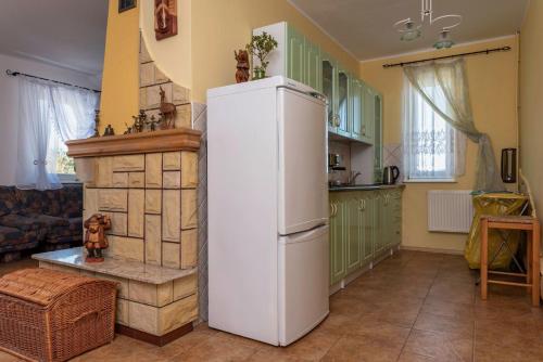 a kitchen with a white refrigerator and a fireplace at Agroturystyka Gawryś pokoje in Sasino