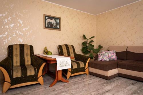 a living room with a couch and a table and chairs at Agroturystyka Gawryś pokoje in Sasino