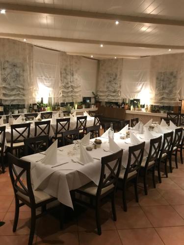 a banquet hall with white tables and chairs with white napkins at Westend Hotel in Ludwigsburg