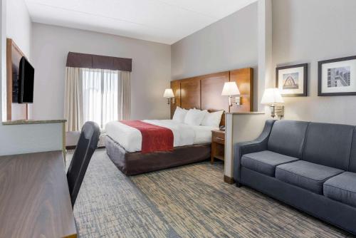 グローブシティにあるComfort Inn Grove City - Columbus Southのベッドとソファ付きのホテルルーム