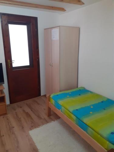 a small bedroom with a bed and a door at Smestaj Stankovic in Soko Banja