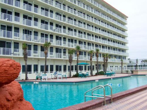 un hotel con piscina frente a un edificio en Daytona Beach - Condo Ocean Front View, en Daytona Beach