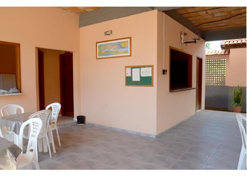 a dining room with a table and white chairs at Agualinda Hotel in Alter do Chao