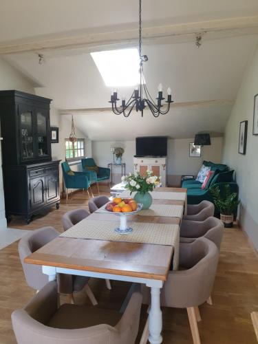 ein Wohnzimmer mit einem Tisch und Stühlen in der Unterkunft Domaine de Bourgville in Monts-sur-Guesnes