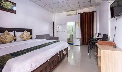 ein Schlafzimmer mit einem großen Bett und einem Schreibtisch in der Unterkunft ลีลาวดีอพาร์ทเมนท์ in Khon Kaen