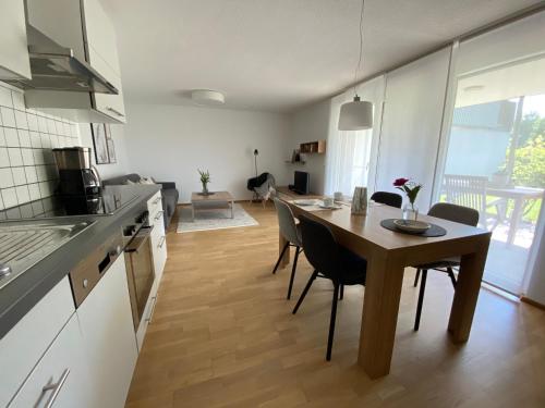 
a kitchen with a table, chairs and a refrigerator at Ferienwohnungen Christine in Dornbirn
