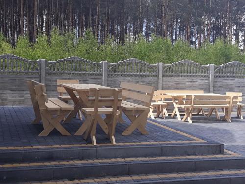 a group of picnic tables and benches next to a fence at Tawerna Akropolis in Ostrów Mazowiecka