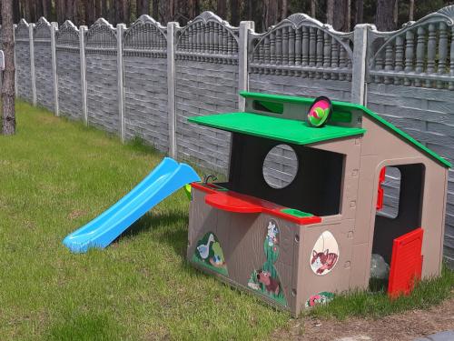 a toy dog house with a slide in the grass at Tawerna Akropolis in Ostrów Mazowiecka