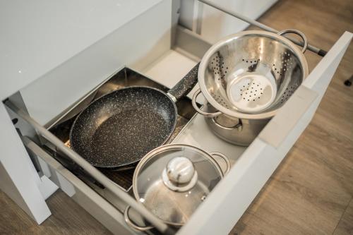 two pots and pans sitting on top of a stove at Baltic Apartments in Pobierowo