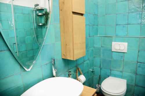 a blue tiled bathroom with a toilet and a sink at Tanya-Apartments and Rooms in Hvar
