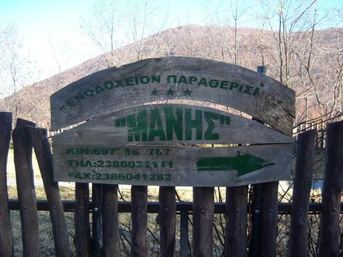 a sign on a fence in front of a mountain at Manis Hotel in Nimfaíon
