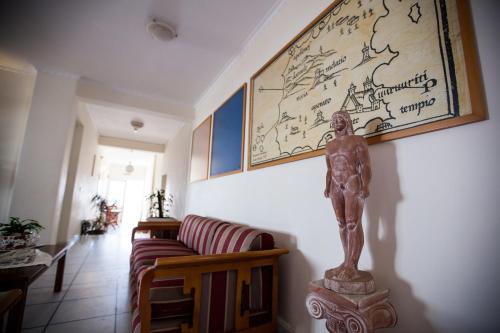 a living room with a statue on a couch and a map at Golden Bay in Agios Prokopios