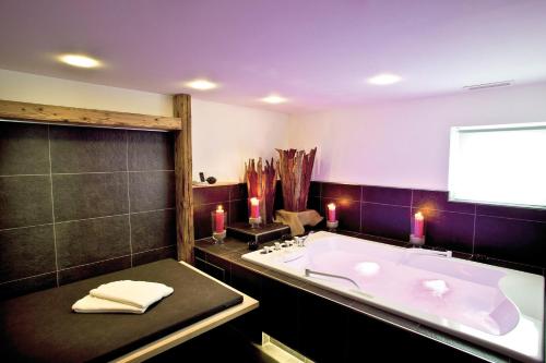 a bathroom with a large bath tub and candles at FidazerHof in Flims