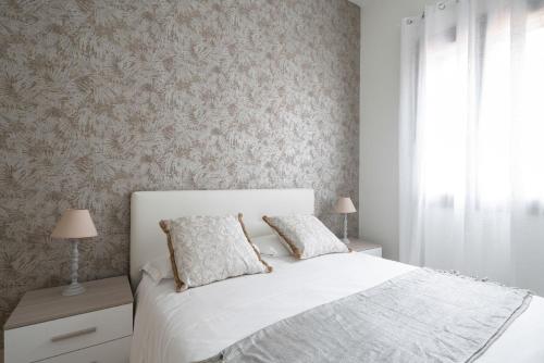 a bedroom with a white bed and a window at Dorsoduro Charme Apartments in Venice