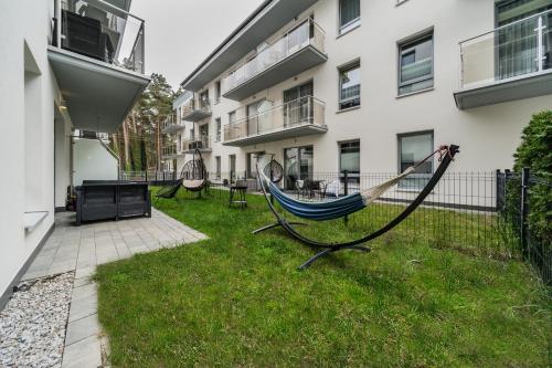 a hammock in a yard next to a building at Baltic Apartments in Pobierowo