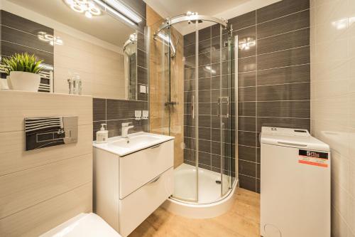 a bathroom with a toilet and a sink and a shower at Baltic Apartments in Pobierowo