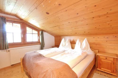 ヴェステンドルフにあるFerienwohnung Örgenhofの木製の部屋にベッド1台が備わるベッドルーム1室があります。