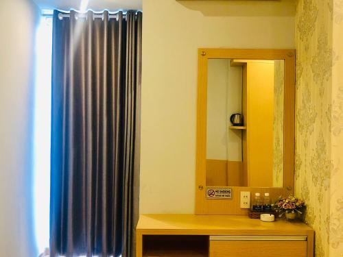 迪石的住宿－Ngoc Thanh Hotel，浴室设有蓝色的浴帘和镜子