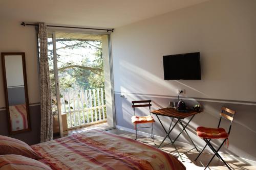 um quarto com uma cama, uma mesa e uma janela em les 3 saisons em Cucuron
