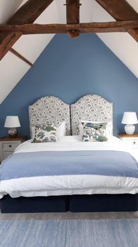 a bedroom with a large bed with blue walls at La Ripaudière in Hambye