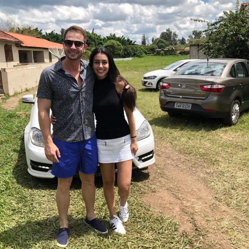 a man and a woman standing next to a car at POUSADA CHARLOTTE in Tiradentes