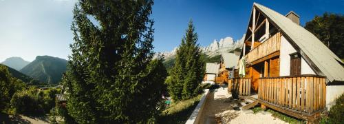 a house with trees and mountains in the background at ETERPA Les chalets de Pré Clos en Vercors in Saint-Andéol