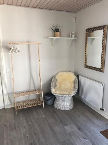 a room with a chair and a mirror on a wall at Rødhus Gl. Skole B&B in Pandrup