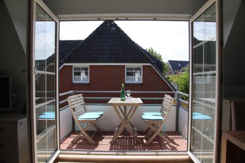 patio con mesa y sillas en el balcón en Sylt Homes Ebbe & Flut, en Westerland