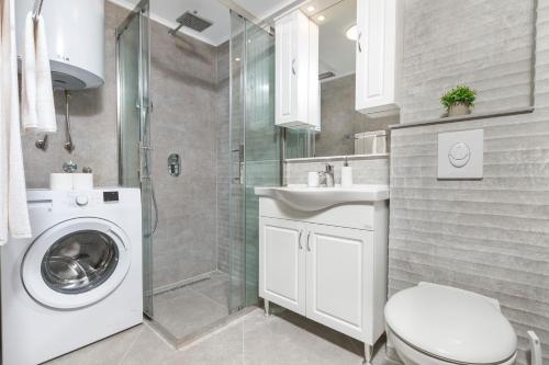 a bathroom with a washing machine and a shower at Old Stone Villa Lalosevic in Kotor