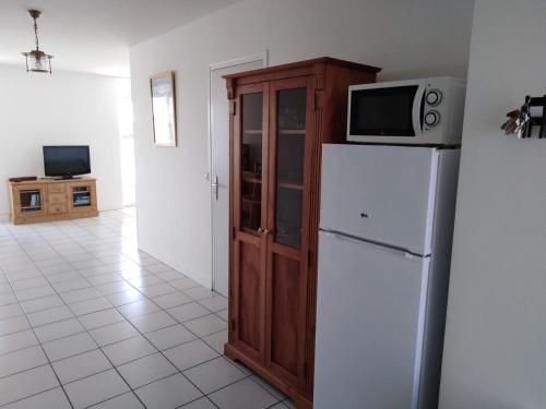 a kitchen with a microwave on top of a refrigerator at L'APPART DU RIS in Douarnenez