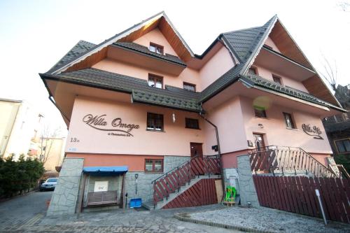 a pink building with a sign on it at Willa Omega in Zakopane