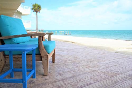 a blue chair sitting on the beach next to the ocean at Glunz Ocean Beach Hotel and Resort in Marathon