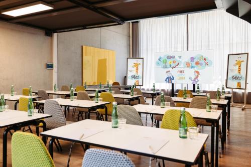 an empty classroom with tables and chairs with bottles on them at Hotel Schani Wien Hauptbahnhof in Vienna
