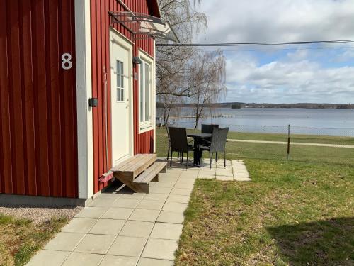 a porch of a red house with a table and chairs at Evedals Camping Växjö in Växjö