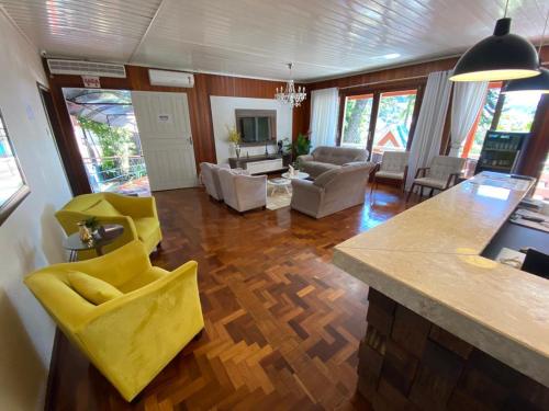 a kitchen and living room with yellow chairs and a counter at Oasis Hotel in Palmitos