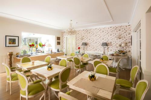 Un restaurante con mesas de madera y sillas verdes. en Solar Sampaio e Melo, en Trancoso