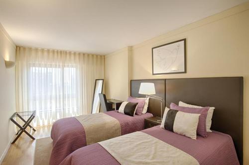 a hotel room with two beds and a window at Green Executive Apartment in the heart of Lisbon in Lisbon