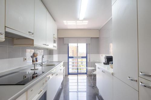 a white kitchen with white cabinets and a sink at Green Executive Apartment in the heart of Lisbon in Lisbon