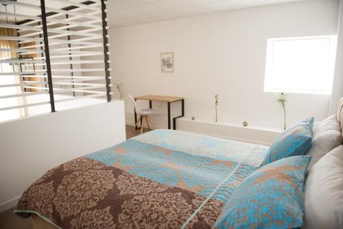 a bedroom with a bed and a table and a window at FRIENDS RESIDENCE Apartments in Timişoara