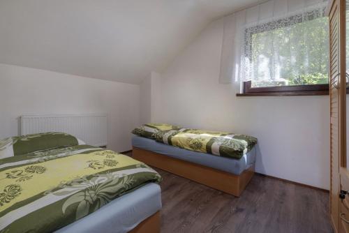 two beds in a room with a window at CHATY - woodyganovce sk in Poprad