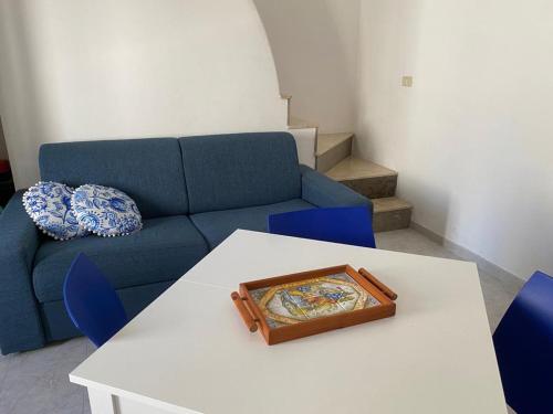 a living room with a blue couch and a table at LA CASETTA DELLE MAIOLICHE in Favignana