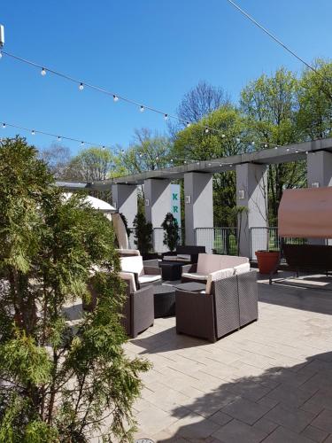 a patio with couches and tables and a canopy at Hotel Polonez in Kraków