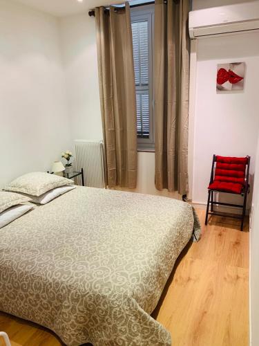 a bedroom with a bed and a red chair at Appartment Le Charme du Bourgeois in Nice