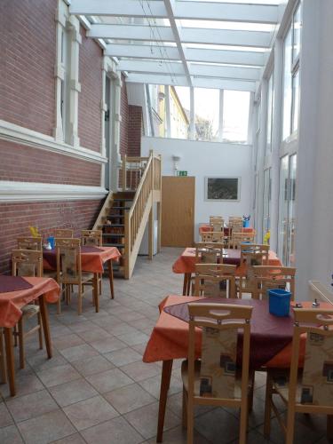 ein Esszimmer mit Tischen, Stühlen und einer Treppe in der Unterkunft Stadtsee-Pension Templin in Templin