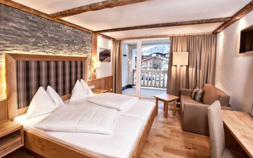 una camera d'albergo con letto e sedia di Hotel Heigenhauser Superior a Waidring