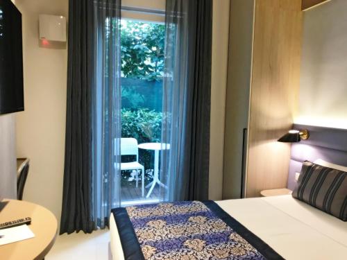 une chambre d'hôtel avec un lit et une fenêtre dans l'établissement Hotel Villa Hermosa, à Riccione