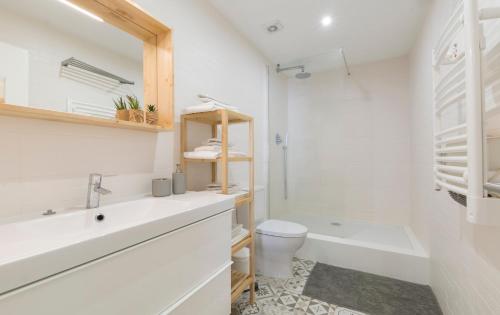 a white bathroom with a sink and a toilet at OrangeTreeHouses in Montijo
