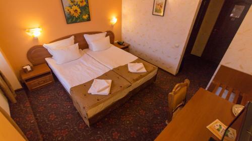 a hotel room with a bed with two tissues on it at Pension La Fontana in Baia Mare