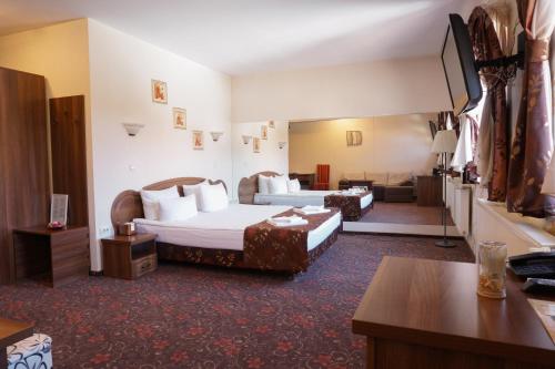 Habitación de hotel con 2 camas y escritorio en Pension La Fontana en Baia Mare