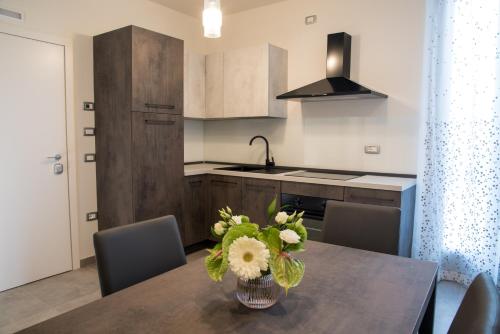 a kitchen with a table with a vase of flowers on it at PALAZZO ILLUMINATI in Ripatransone